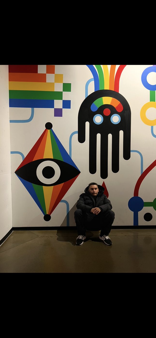Belinskii seated in front of a colorful geometric mural
