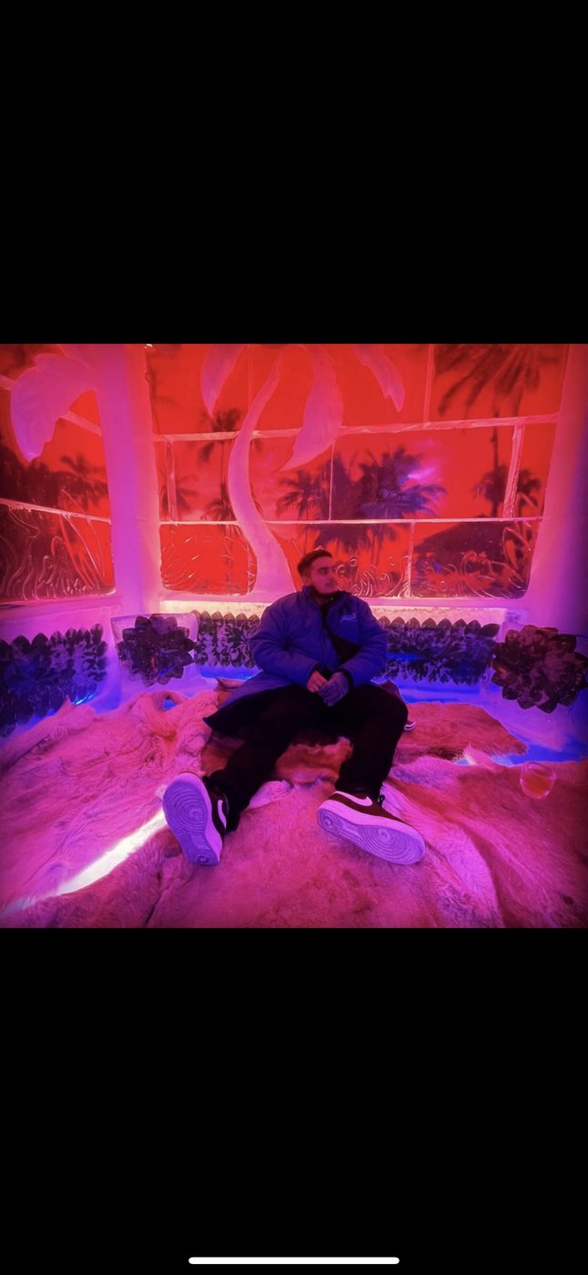 Belinskii in an ice bar with carved palm trees and pink lighting